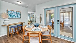 Uma área de refeições com uma mesa redonda, banquetas estofadas com padrão azul e branco e uma tigela decorativa grande.