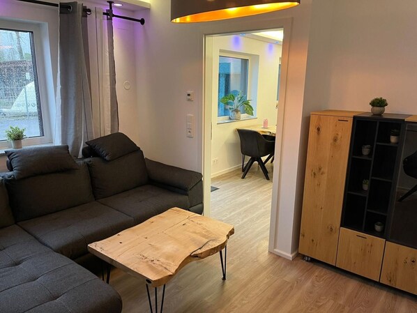 A modern living room with a sofa, a coffee table, and a wooden cabinet.