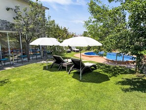 Um quintal com piscina, área de estar externa e varanda envidraçada.
