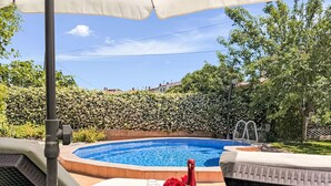 Ein Poolbereich mit Pool, Liegestühlen und einem Tisch mit Flasche und Gläsern.