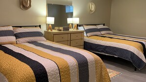 Een hotelkamer met twee bedden, een dressoir en een spiegel.