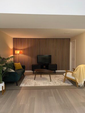 A modern living room with a TV, sofa, and coffee table.