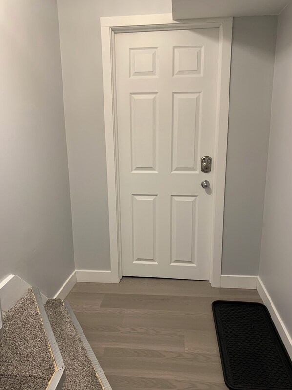 A white door with a keyhole lock and a doorbell.