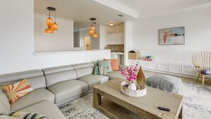 A living room with a grey sofa, a wooden coffee table, and pendant lights. - 3 Bedroom Townhome-Resort Style Pool (Corpus Christi)