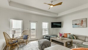 A spacious living room with a sofa, chairs, a coffee table, and a television. - 3 Bedroom Townhome-Resort Style Pool (Corpus Christi)