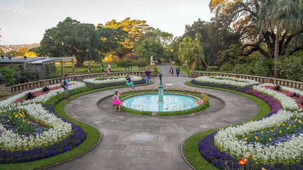 A circular garden with a central fountain, surrounded by flower beds and pathways. - KozyGuru | Potts Point | Stylish Inner-City Studio (Potts Point)