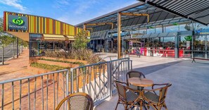 A Woolworths store with outdoor seating and a modern architectural design. - KozyGuru | Box Hill | New Designer Home (Box Hill)