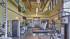 Ett gym med olika typer av träningsutrustning, inklusive löpband och styrketräningsmaskiner.