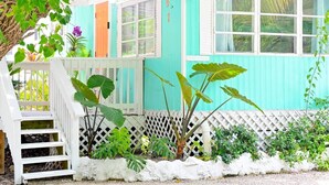 A turquoise house with a white porch and a small staircase. - The HotTub Hideaway-5 Min From Sombrero Beach (Marathon)