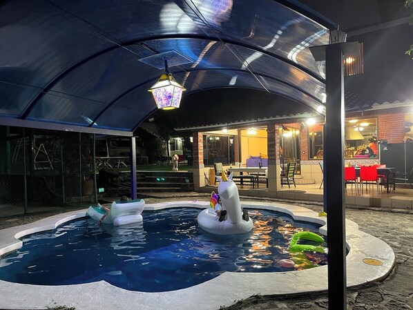 A swimming pool with inflatable swans and a lantern.