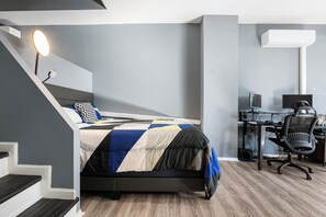 A modern bedroom with a bed, a desk, and a chair.