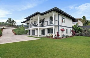 A two-story modern house with a flat roof, large windows, and a covered front porch. - Kona Charmer: Ocean View, Arcade Room (Kailua-Kona)