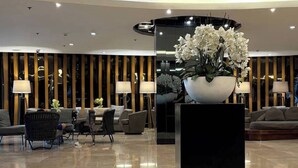 Eine moderne Lobby mit glänzendem Boden, einer Sitzecke und einer großen Blumenkomposition.