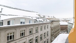 Une vue d’un bâtiment doté de nombreuses fenêtres et dont le toit est recouvert de neige.