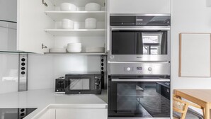 Une cuisine compacte équipée d’un four à micro-ondes, d’un grille-pain et de deux fours classiques.