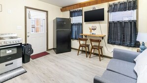 A compact kitchen with a stove, refrigerator, and a small dining area with two chairs. - Spacious 2BR Apt • Free Parking • Baden (Baden)