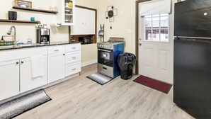 A compact kitchen with white cabinets, a stove, a microwave, and a refrigerator. - Spacious 2BR Apt • Free Parking • Baden (Baden)