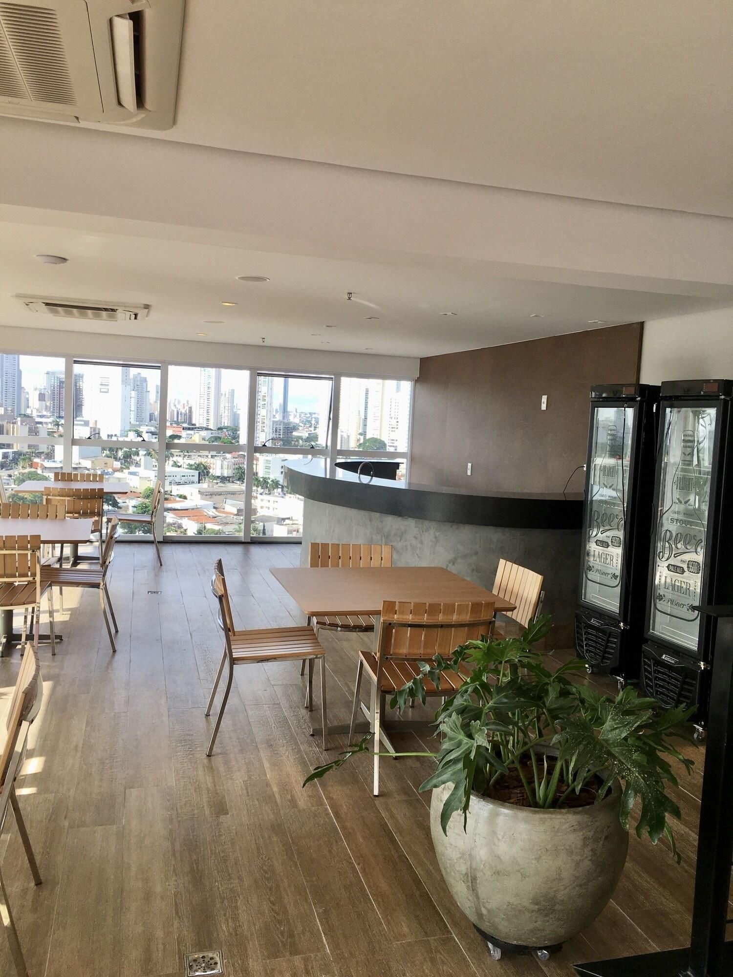 Un interior moderno con comedor, ventanas amplias y vista a la ciudad.