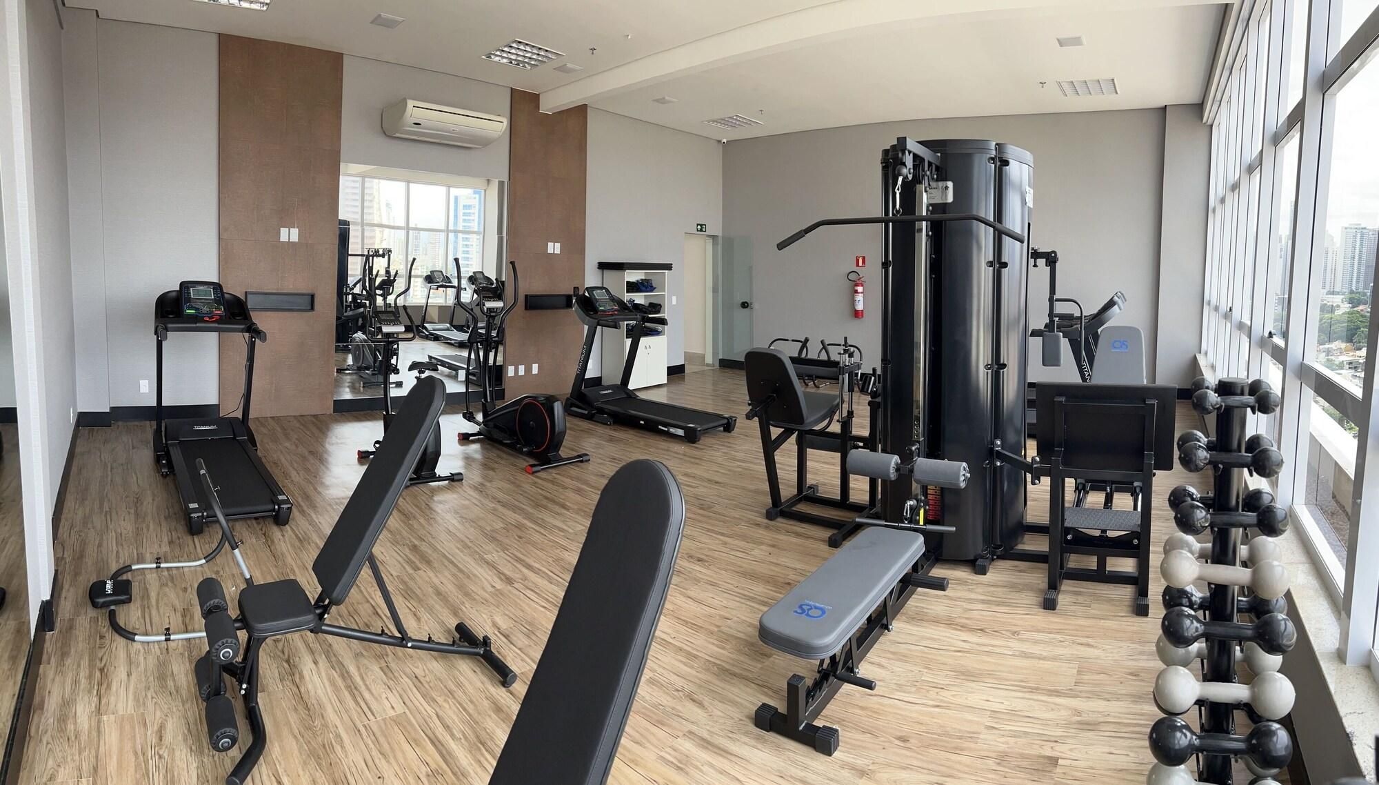 Un gimnasio moderno con cintas de correr, máquinas de pesas y una variedad de equipos de ejercicio.