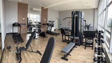 Un gimnasio moderno con cintas de correr, máquinas de pesas y una variedad de equipos de ejercicio.