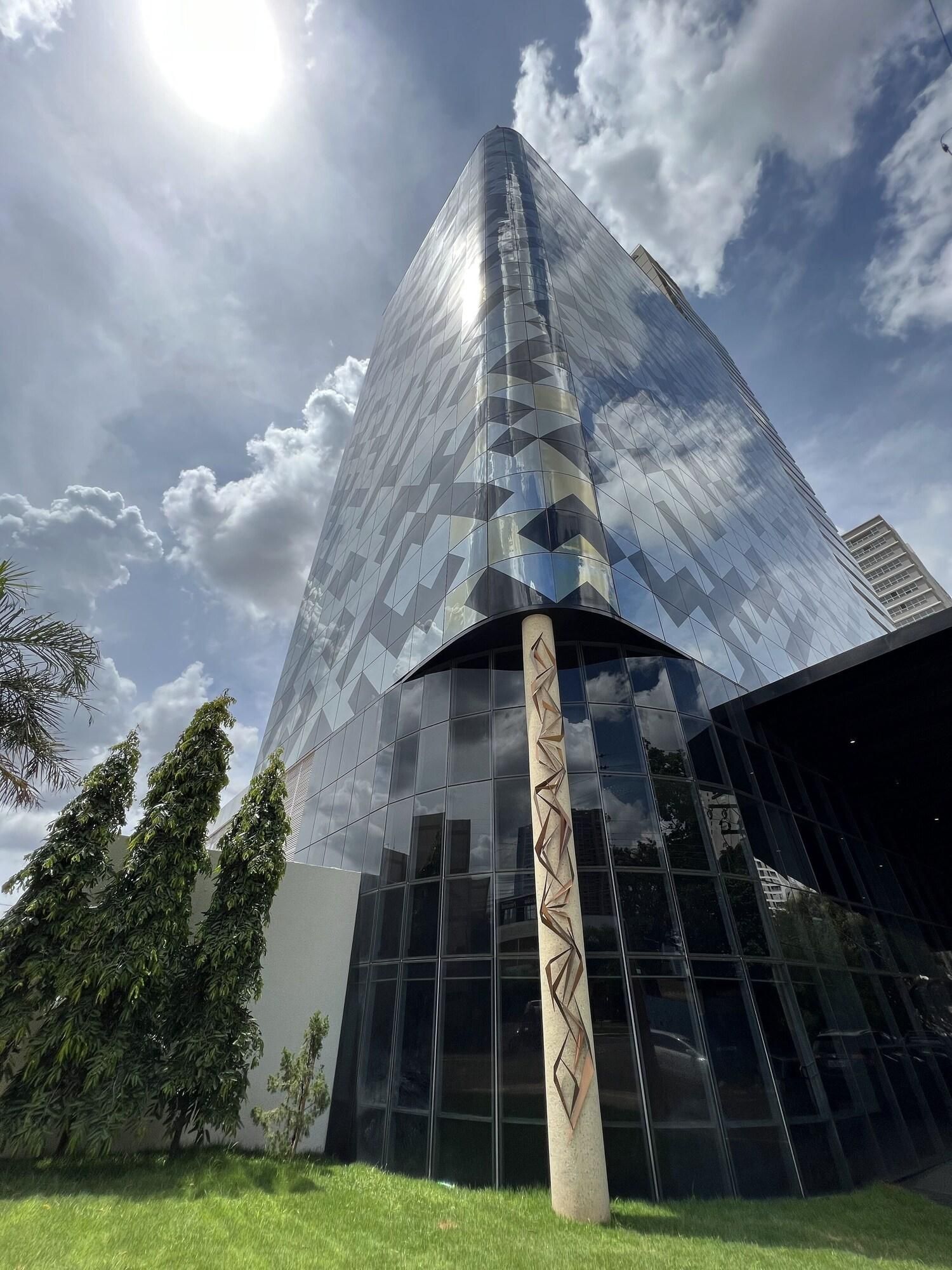 Un edificio moderno con fachada de vidrio reflectante y un diseño geométrico.