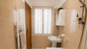 Ein Badezimmer mit Badewanne, Waschbecken, Dusche und Handtuchhalter.