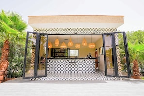 A modern bar with a patterned floor and hanging pendant lights. - Weedan Ferme D'hôtes (Marrakech)