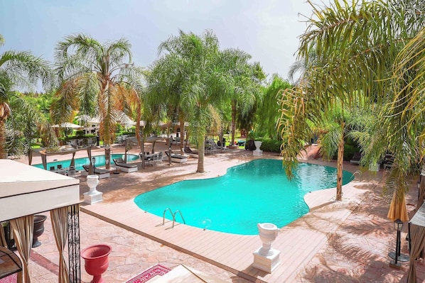 A pool area with lounge chairs, a small pool, and surrounding palm trees. - Weedan Ferme D'hôtes (Marrakech)