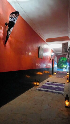 A corridor with red walls, a patterned rug, and lanterns. - Weedan Ferme D'hôtes (Marrakech)
