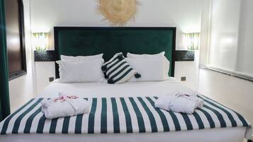 A neatly made bed with striped bedding, white pillows, and a sun-shaped wall decoration.