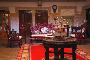 A traditional room with a red carpet, ornate furniture, and a patterned wall. - Weedan Ferme D'hôtes (Marrakech)