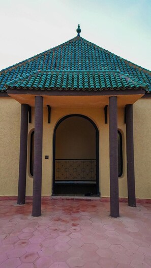 A building with a tiled roof, an arched entrance, and a hexagonal tiled floor. - Weedan Ferme D'hôtes (Marrakech)