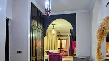 A spacious living room with a large rug, a sofa, and a dining area.
