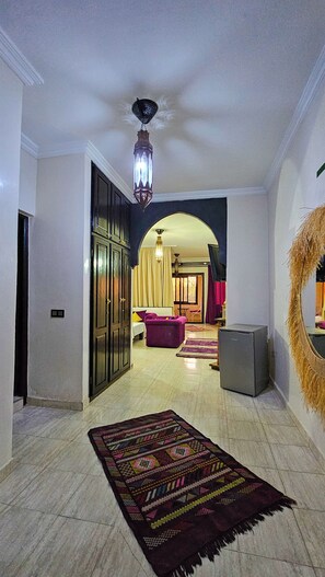 A spacious living room with a large rug, a sofa, and a dining area. - Weedan Ferme D'hôtes (Marrakech)