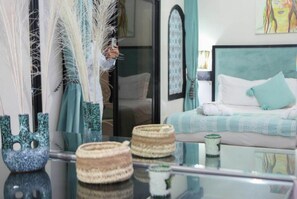 A room with a bed, a glass table with woven baskets, and decorative feathers. - Weedan Ferme D'hôtes (Marrakech)