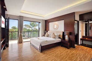 A modern bedroom with a large bed, a TV, and a balcony with a view of trees. - Nara Villa Canggu By Ini Vie Hospitality (Payangan)