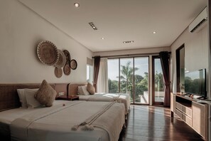 A modern hotel room with two beds, a flat-screen TV, and a balcony with a view of palm trees. - Nara Villa Canggu By Ini Vie Hospitality (Payangan)