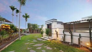 A modern house with a paved pathway, palm trees, and cacti. - Nara Villa Canggu By Ini Vie Hospitality (Payangan)