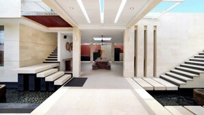 A modern interior with a central staircase, a seating area, and a view through a glass ceiling. - Nara Villa Canggu By Ini Vie Hospitality (Payangan)