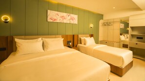 Une chambre d’hôtel avec deux lits, un mur d’accent de couleur verte et un tableau représentant des flamants roses.