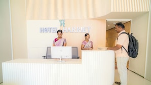 Un comptoir d’accueil à l’hôtel Harriet, équipé d’un ordinateur et d’un téléphone.