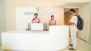 A reception desk at the Hotel Harriet with a computer and a telephone.
