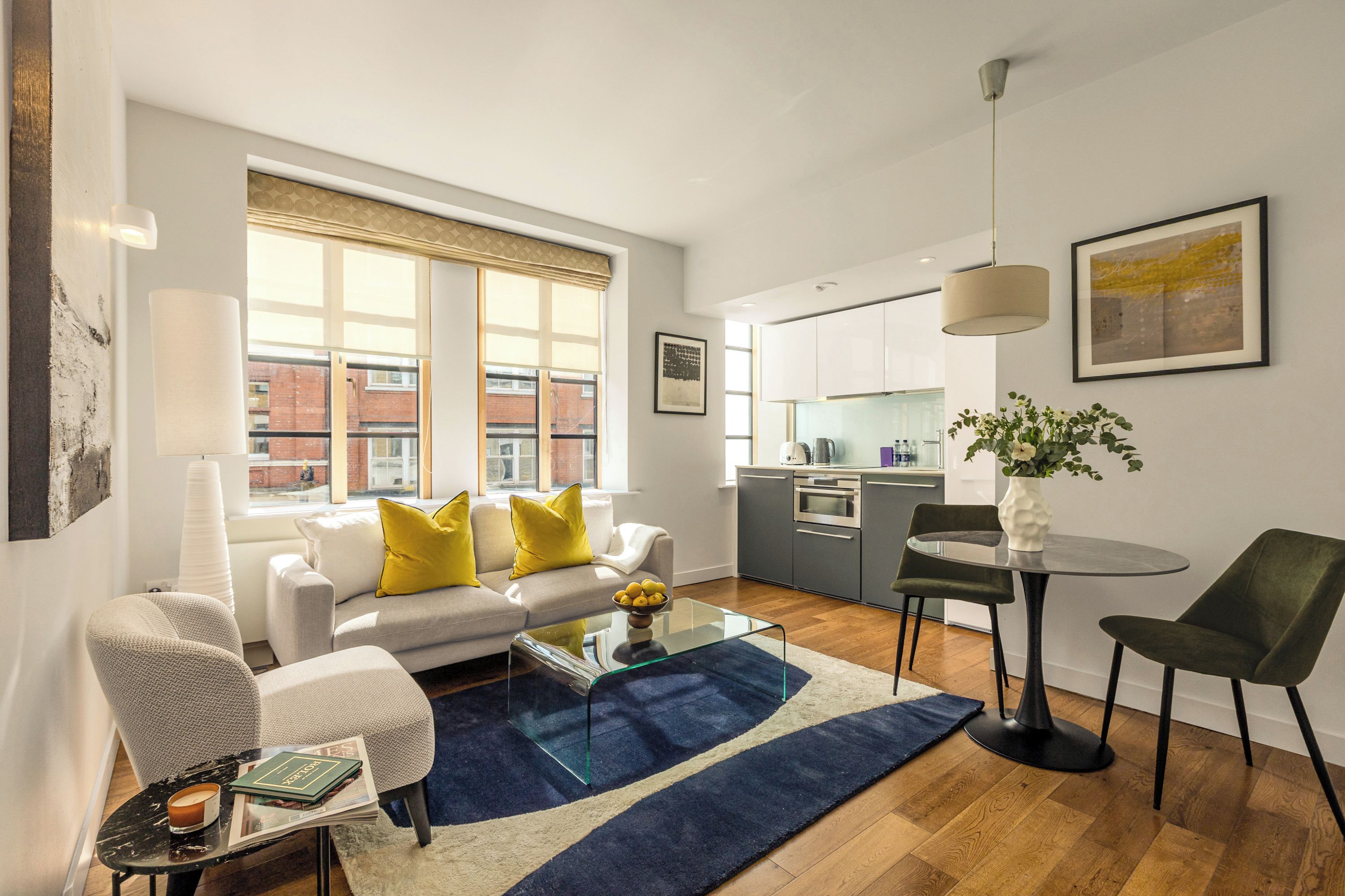 A modern living room with a sofa, coffee table, and dining area.