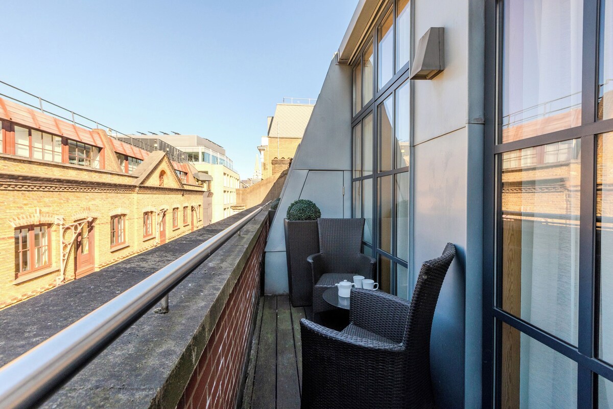 A balcony with wicker furniture, a small table, and a potted plant.