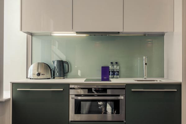 A modern kitchen with a built-in oven, a coffee maker, and a water dispenser. - Liverpool Street - Your Apartment (London)