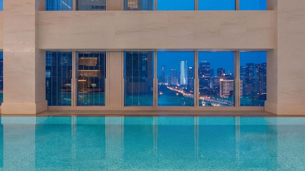A modern building with a pool and large windows offering a cityscape view. - Grand Skylight International Hotel Jinan (Jinan)
