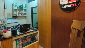 A room with a wooden counter, a computer, and a sign that reads 'CAPSULE'. - Capsutel (Baguio)