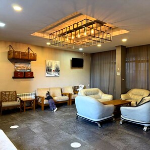 A modern living room with a sofa set, a coffee table, and a decorative light fixture. - Papillat Vip Llc (Batumi)