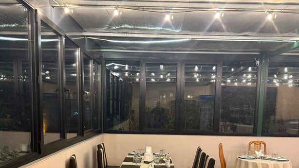 A dining area with a long table set for four, surrounded by chairs with yellow cushions. - Papillat Vip Llc (Batumi)