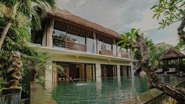 A two-story building with a pool, surrounded by tropical vegetation. - Campania Villa Bali (Sukawati)